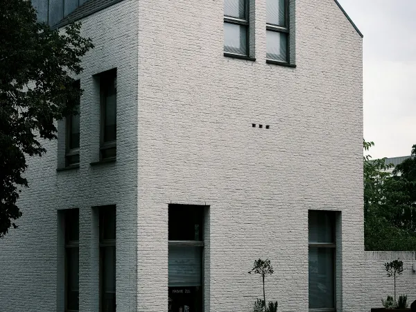 Nieuwe woning van witte baksteen met hoge smalle ramen