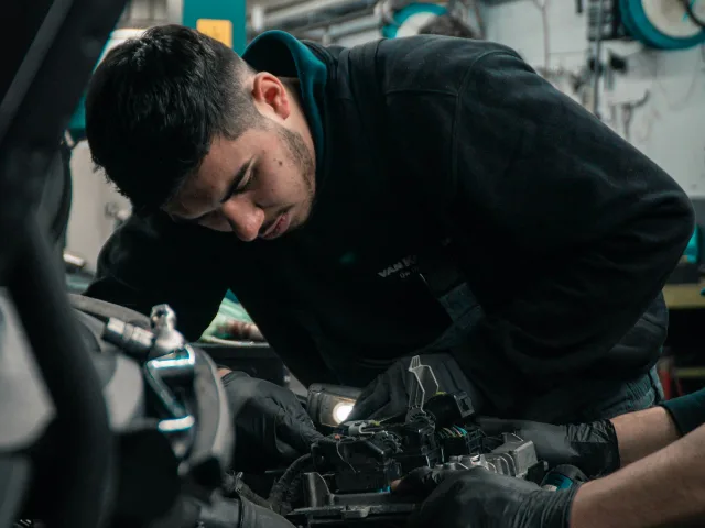 Monteur werkt met handschoenen aan de motor