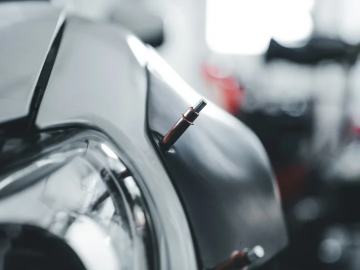 Puntlasser tegen het plaatwerk van een auto in de werkplaats