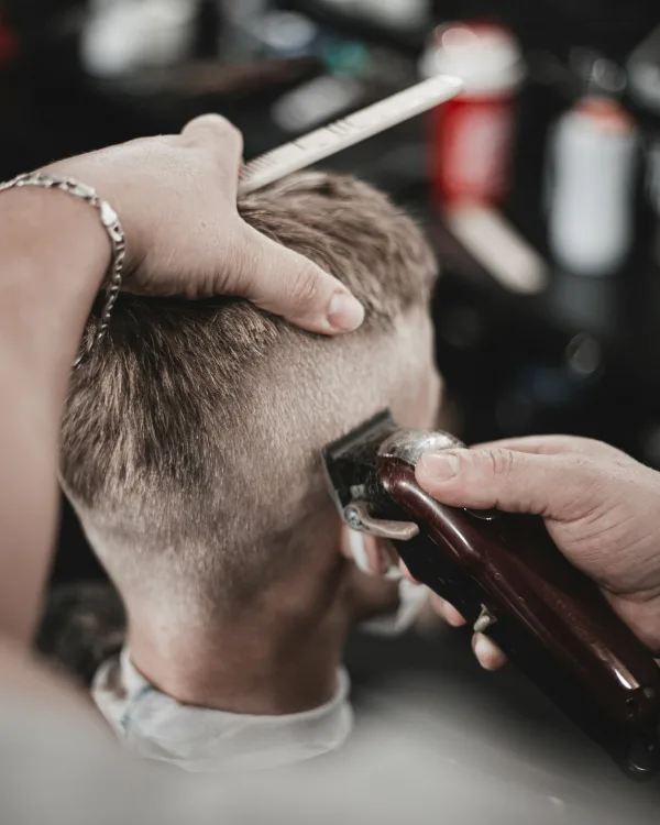 Achterkant van een korte fade die met de tondeuse wordt bijgewerkt