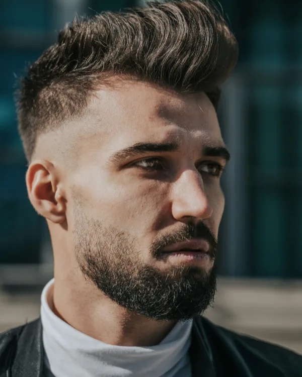 Man met een opgeföhnde quiff, korte zijkanten en een kort bijgehouden baard