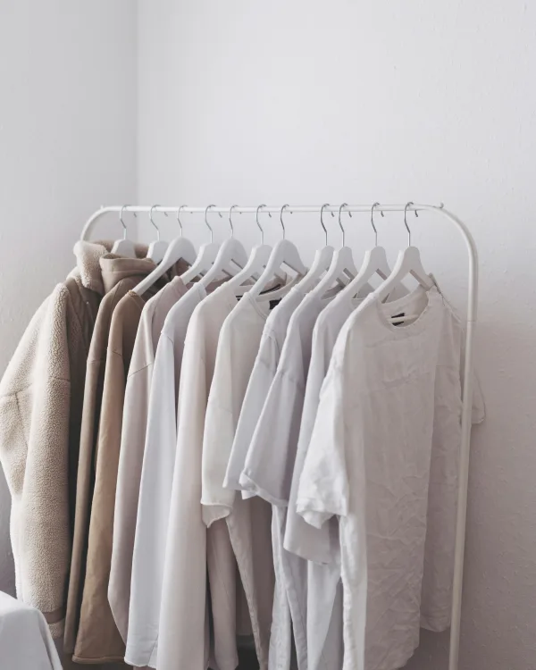 Een rek met shirts en truien in wit, zand en ecru