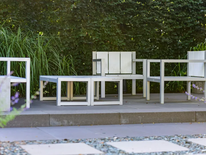 Modern terras met witte tuinmeubels, grind en lage beplanting
