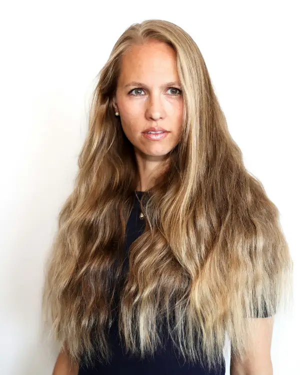 Vrouw met lang golvend haar in warme blondtinten