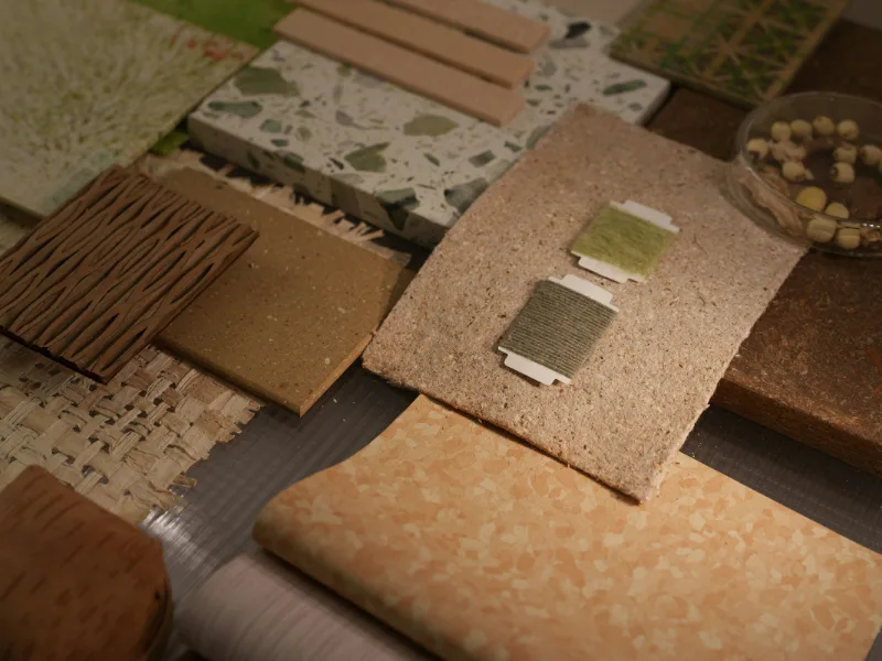 Materiaalstalen van hout, terrazzo, kurk en stof op een tafel