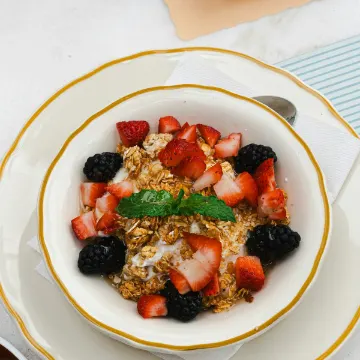 Kom yoghurt met granola, aardbeien en bramen