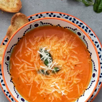 Oranje soep in een kom met een rand van stippen