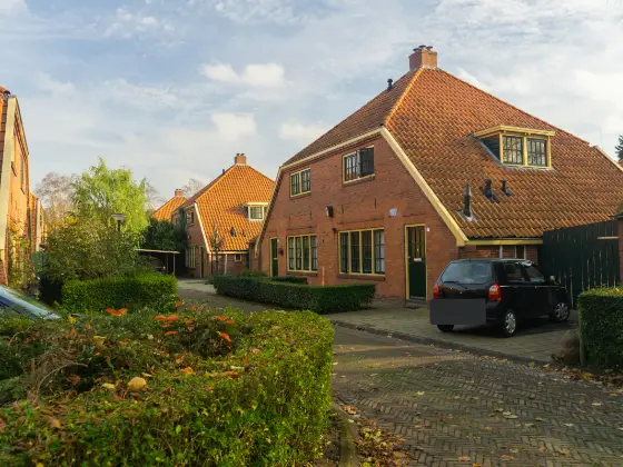 Twee-onder-een-kapwoning met oranje dakpannen en een dakkapel aan een klinkerstraat