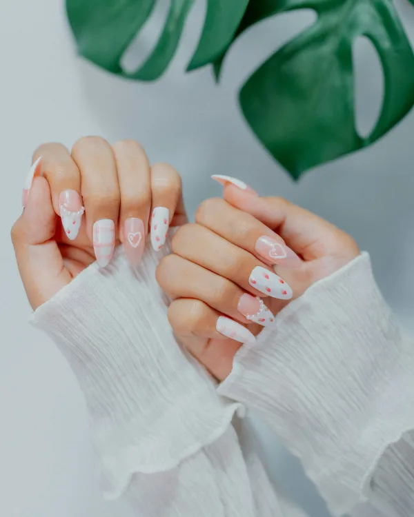 Witte amandelnagels met kleine roze hartjes en stippen