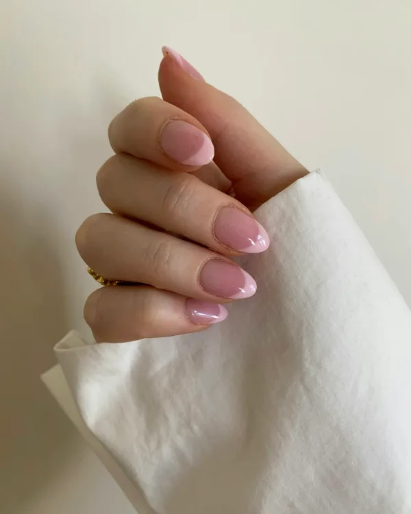 Hand met korte lichtroze nagels die een wit doekje vasthoudt