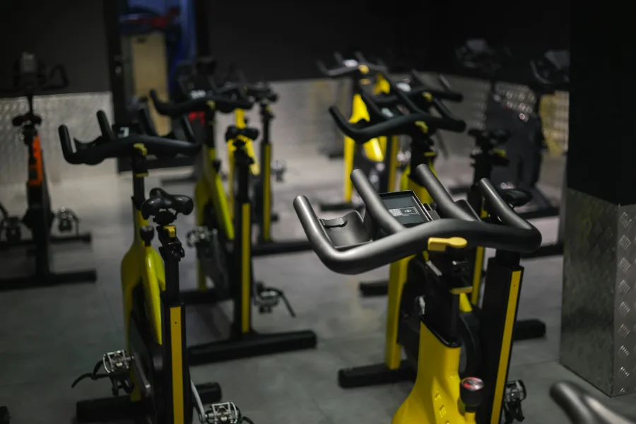 Spinningzaal met rijen fietsen in geel en zwart