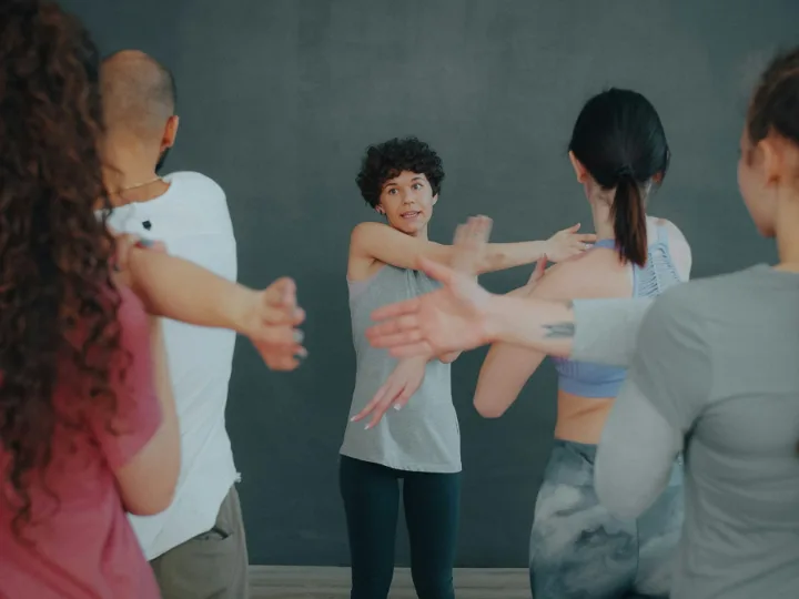 Een groep strekt de armen uit tijdens een rustige les in de studio