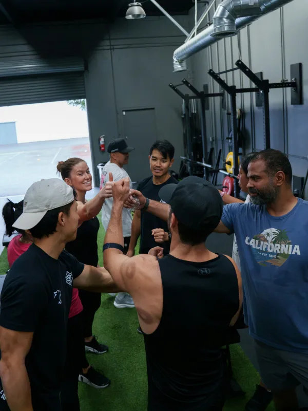 Een groep sporters geeft elkaar een high five na de bootcamp
