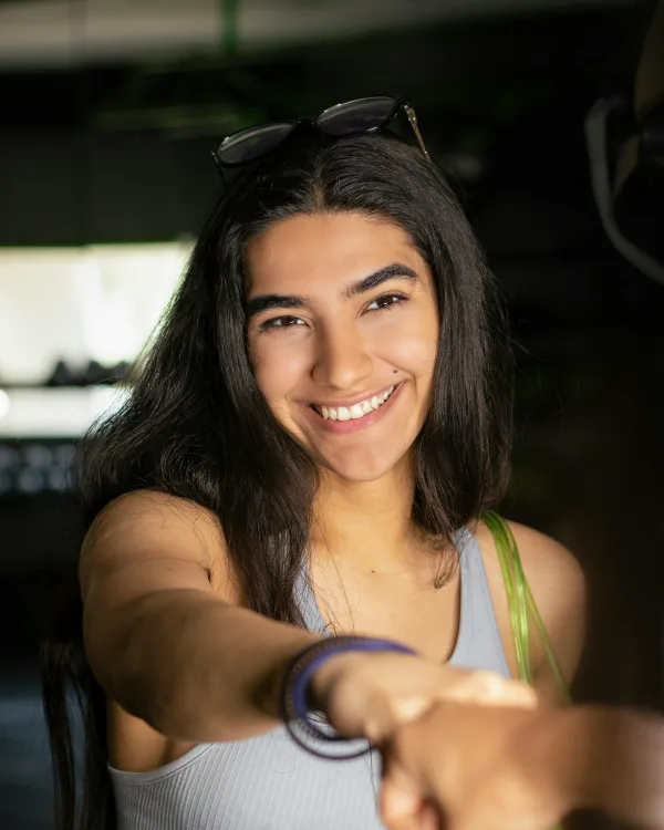 Yara lacht en steekt haar vuist uit naar de camera