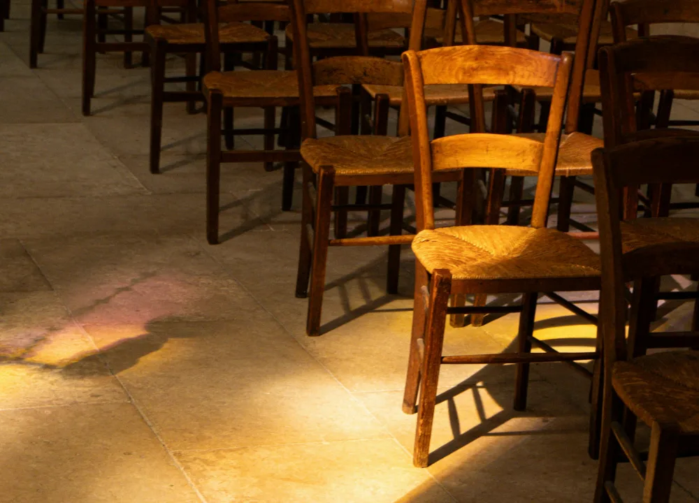 Houten stoelen in een stille ruimte waar het zonlicht op de vloer valt
